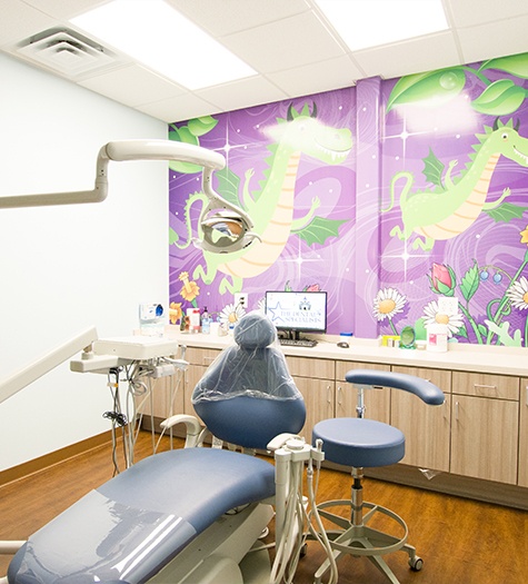 Child and parent smiling at dentist in dental exam room