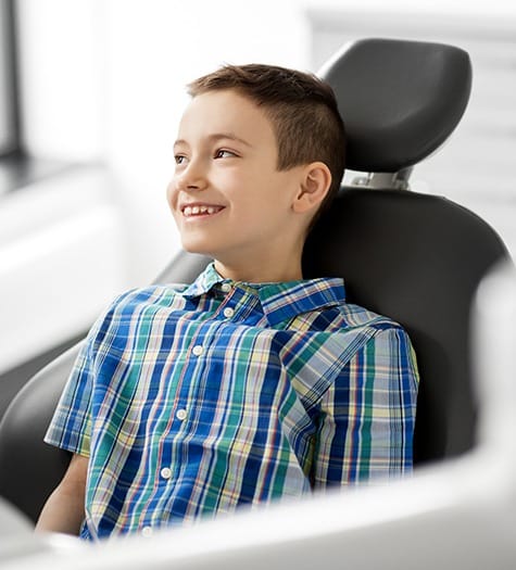 Child in dental chair smiling