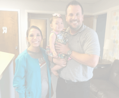 Garland pediatric dentist holding a baby