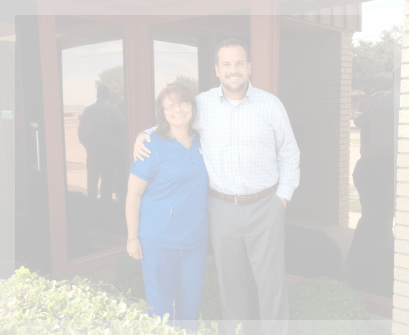 Smiling pediatric dentist and dental team member outside of dental office in Garland