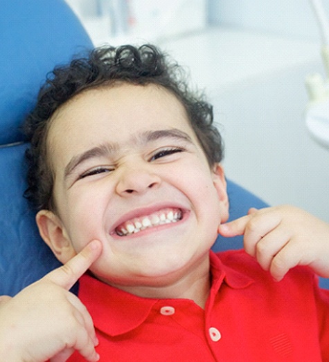 Little boy smiles after visiting his Garland pediatric dentist 