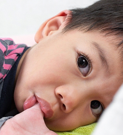 Boy sucking his thumb should see Garland pediatric dentist 