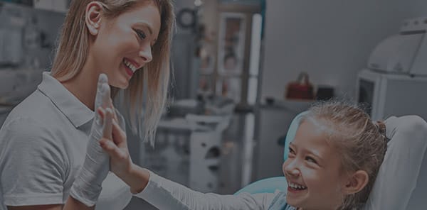 Little girl giving dental team member a high five