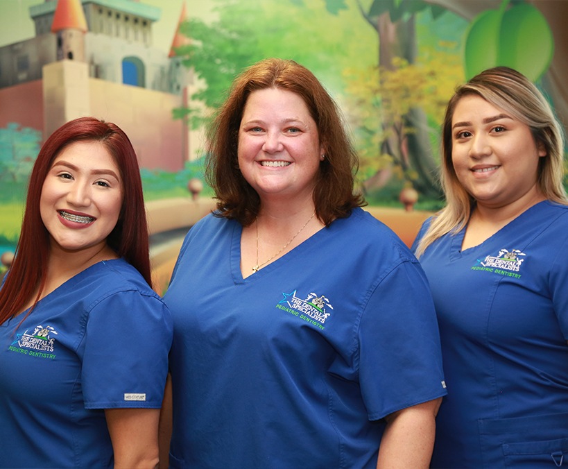 Parents and two kids checking in at dental office reception desk