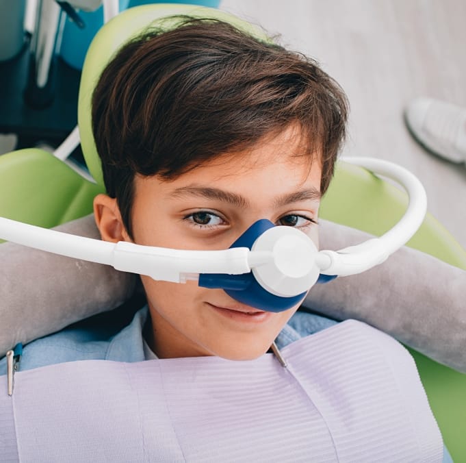 Young boy in dental chair with nitrous oxide sedation dentistry mask