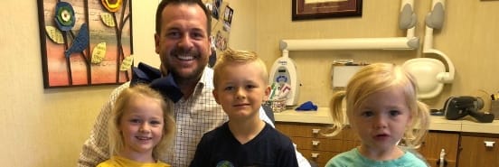 Doctor Preece and three kids in dental exam room