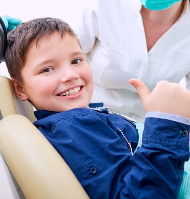 Child giving thumbs up after sedation dentistry visit