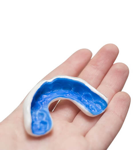 An up-close view of a hand holding a custom-made mouthguard