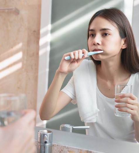 A teenager brushing her teeth