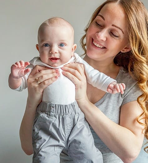 Mother holding up smiling baby