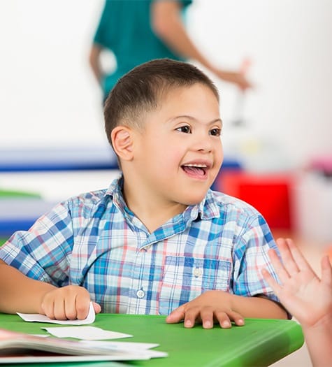 Young boy smiling in a classroom