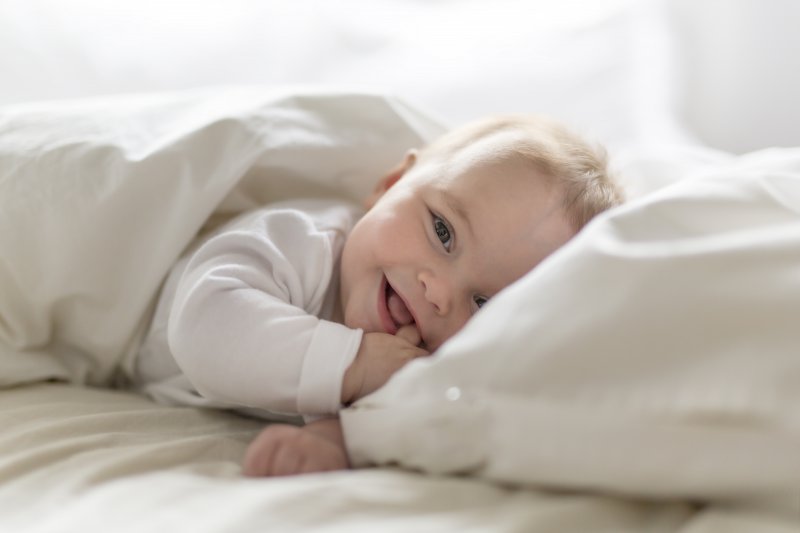 Baby smiling while lying in bed