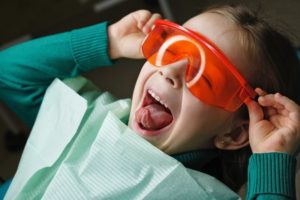 child smiling as they're having dental sealants in Garland placed in their mouth