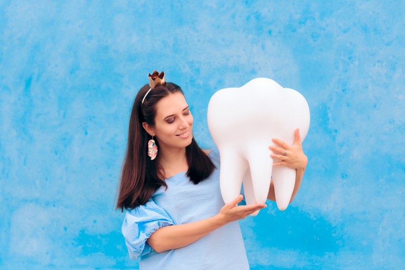 Tooth fairy holding a large tooth mold in Garland 