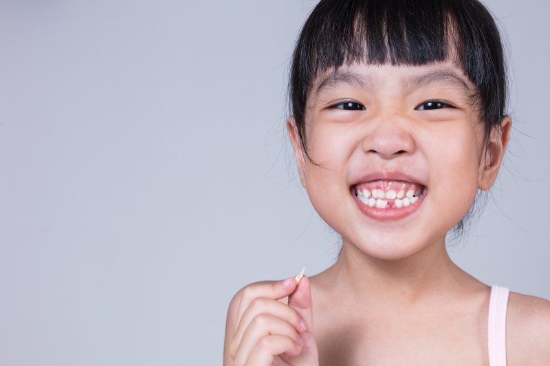 Young girl holding a tooth in her hand 