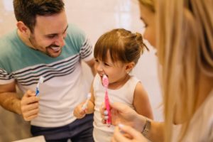 parent brushing teeth with their child 