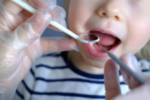 a dentist examining a child’s smile 