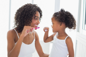 a parent brushing her child’s teeth