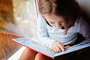 Young child reads a book.