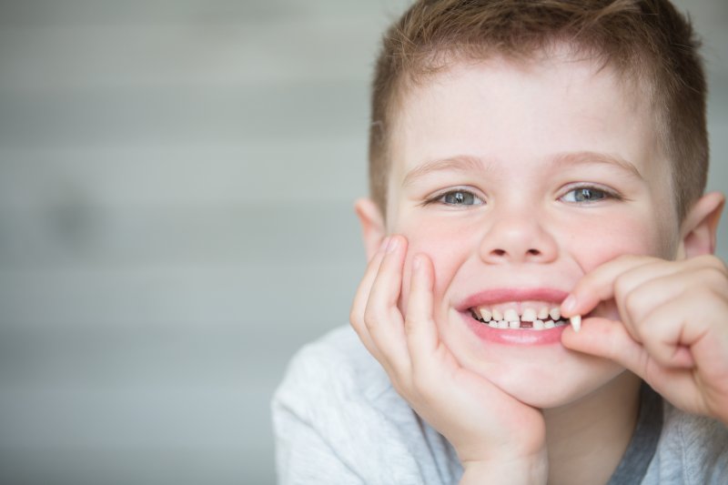 little boy holding knocked-out tooth