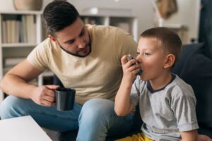 Father helping his son with asthma 