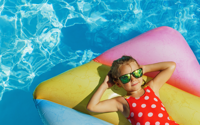 Little girl with sunglasses on pool float