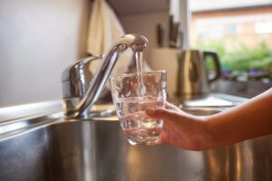 Child filling glass with water